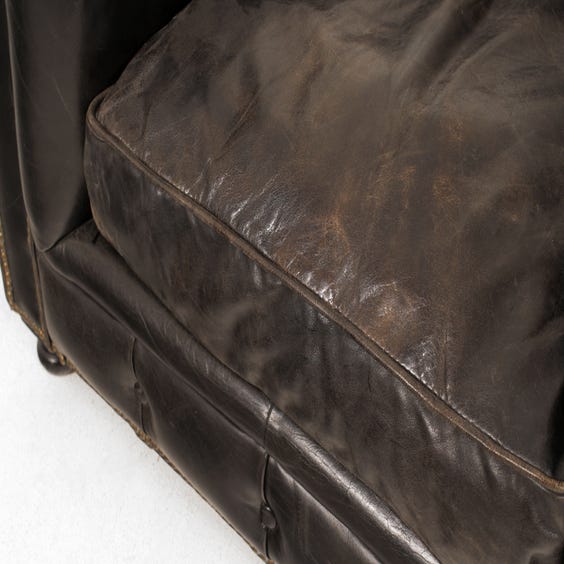 image of Aged black leather Chesterfield armchair