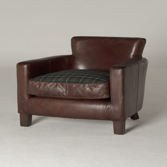 image of Brown leather armchair tartan cushion