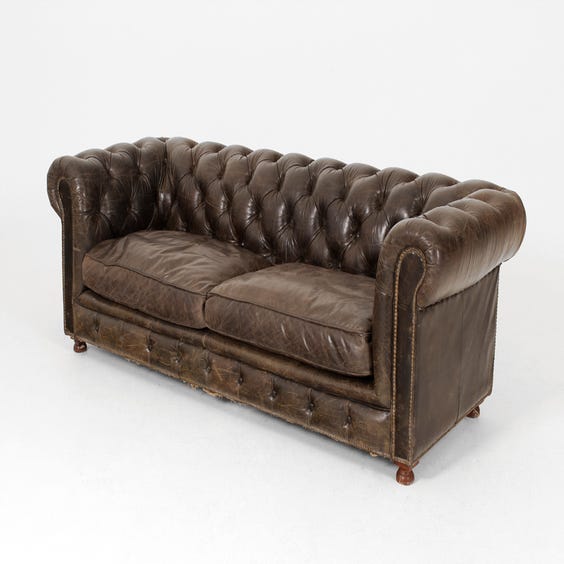 image of Aged black leather Chesterfield sofa